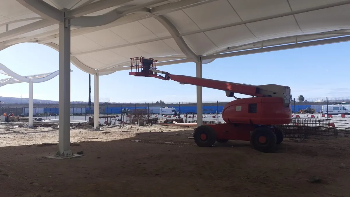 Nacelle articulée diesel déployée sous une halle en construction